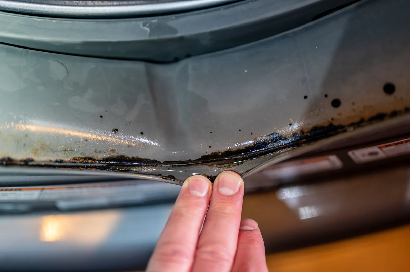 How to clean a front-load washer gasket with visible mold in the rubber fold.